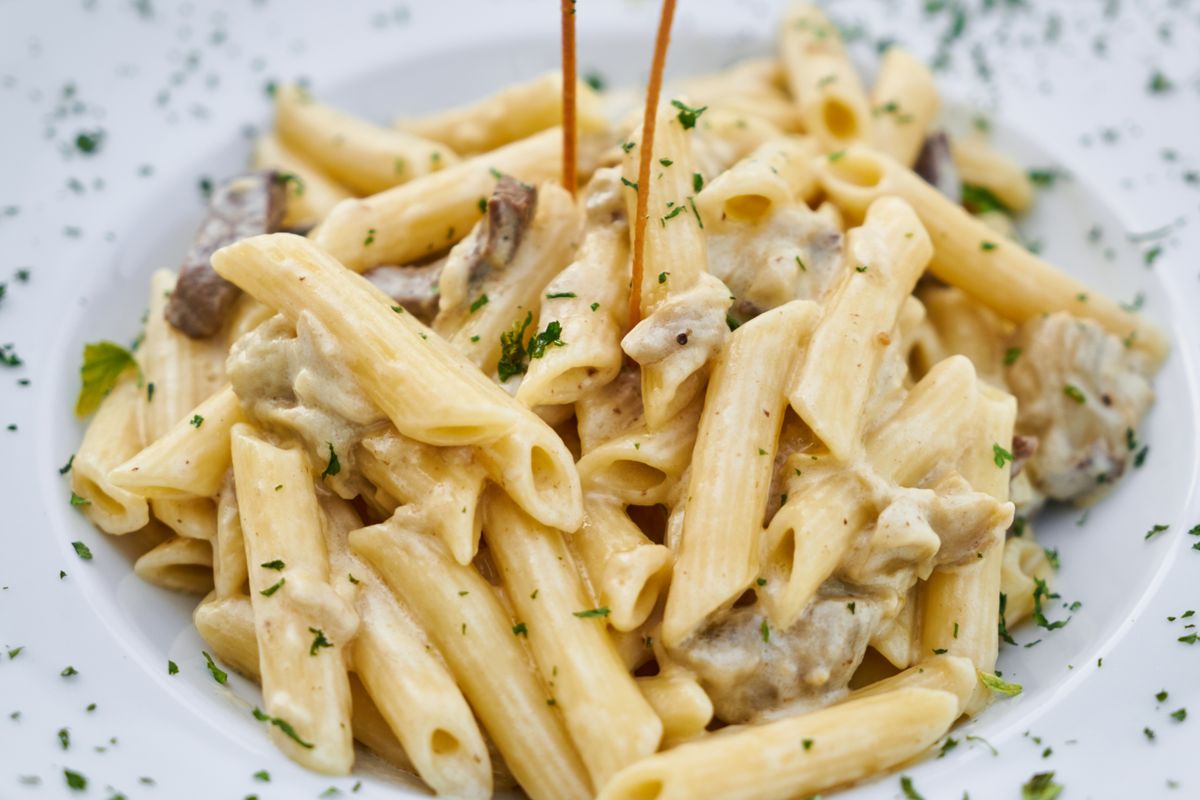 Illustrative food photograph: creamy pea pasta with a lighter pan sauce