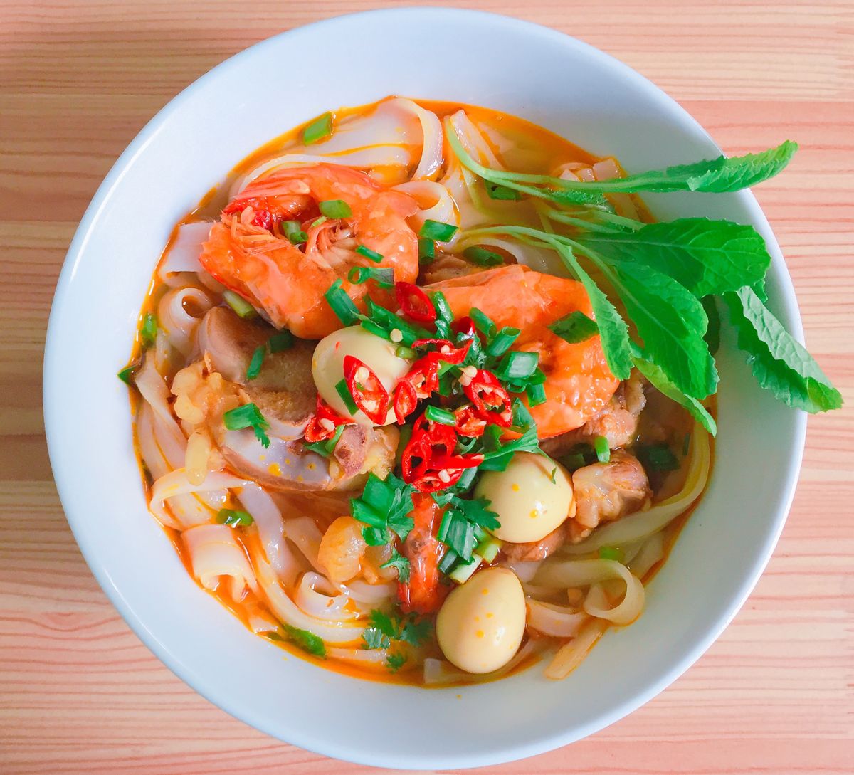 Illustrative food photograph: tomato and coconut prawn soup